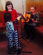 (l to r) Mattie Hood, Amelia Hood, and Aeryn Anderson provide special music for the Sunday morning service.  Photo by Archie Collins.